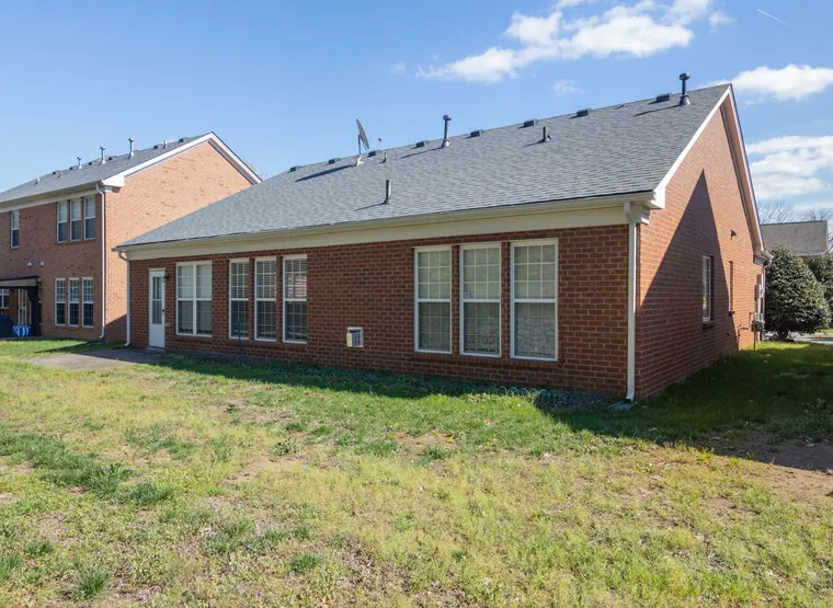 Rear elevation of the brick single-story home with lawn