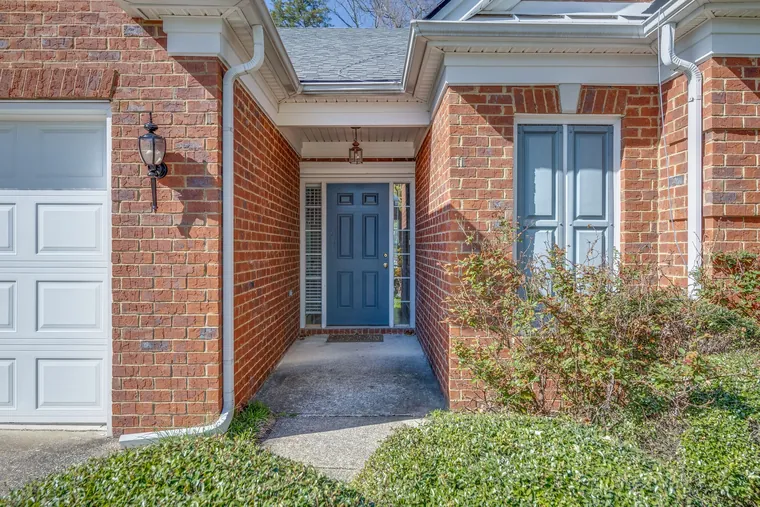 Covered brick entry with blue door